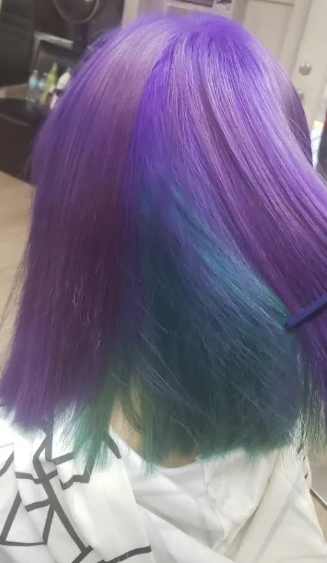 Vivid purple-to-teal creative color on long hair.
