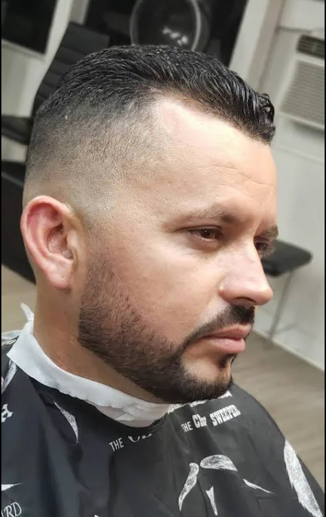 A skin fade blended into a sharp beard line-up.