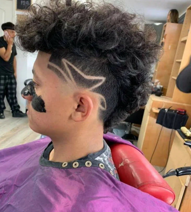 Curly mohawk with a freehand star shaved into the side.