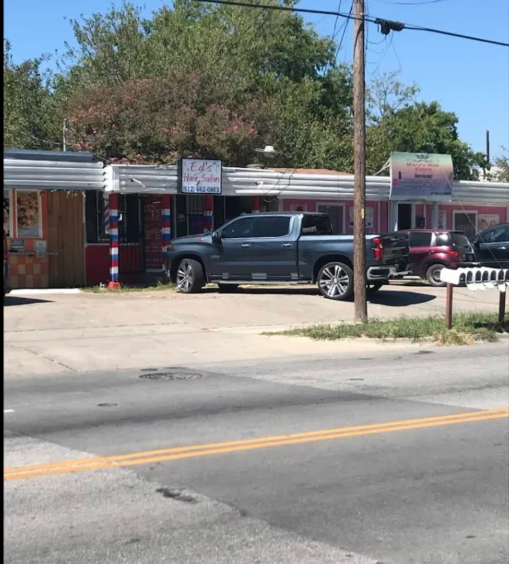 The Ed's storefront on Montopolis Drive with a striped barber pole out front.