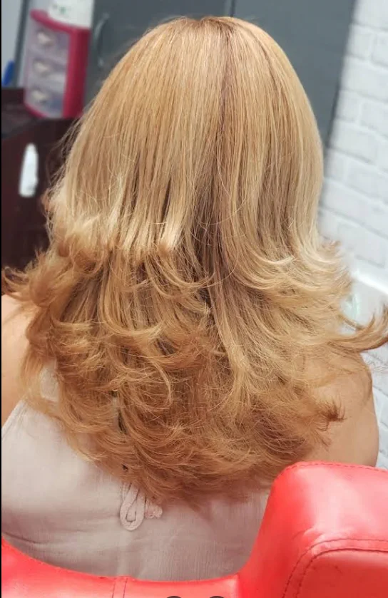 Strawberry-blonde layered cut with a bouncy blowout.
